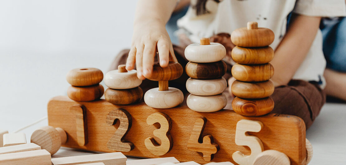 Kind spielt mit Holzringen, © https://images.pexels.com/photos/15380960/pexels-photo-15380960.jpeg